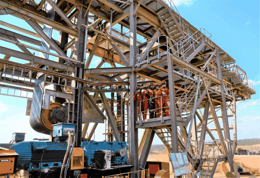 Workers on an elevated steel platform at a mining and construction site